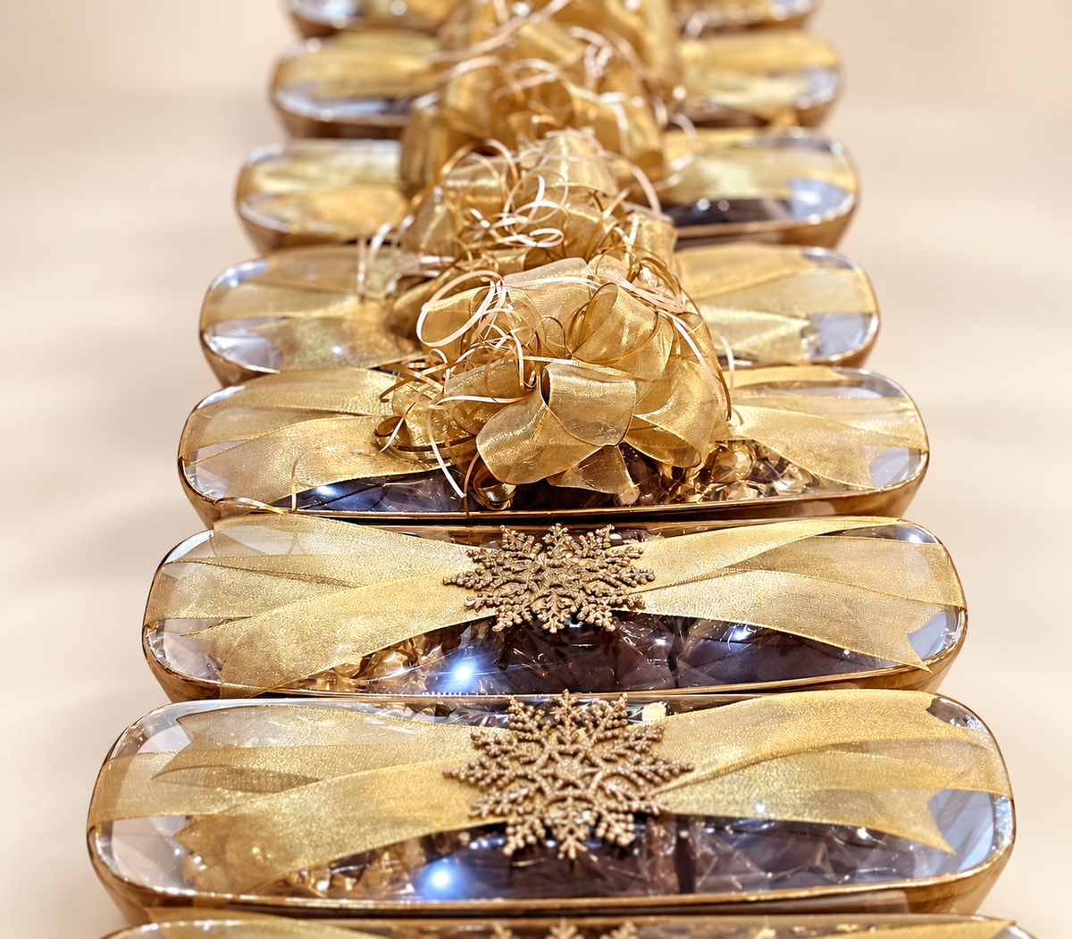 Corporate gift bowls filled with chocolates, wrapped with gold ribbon and snowflake accents