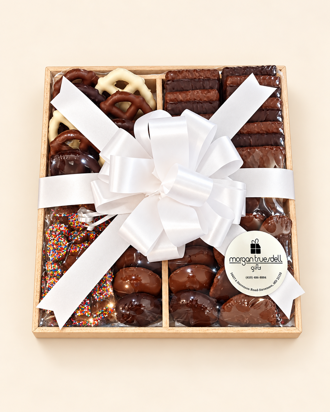 Wooden tray of chocolate treats tied with white satin bow
