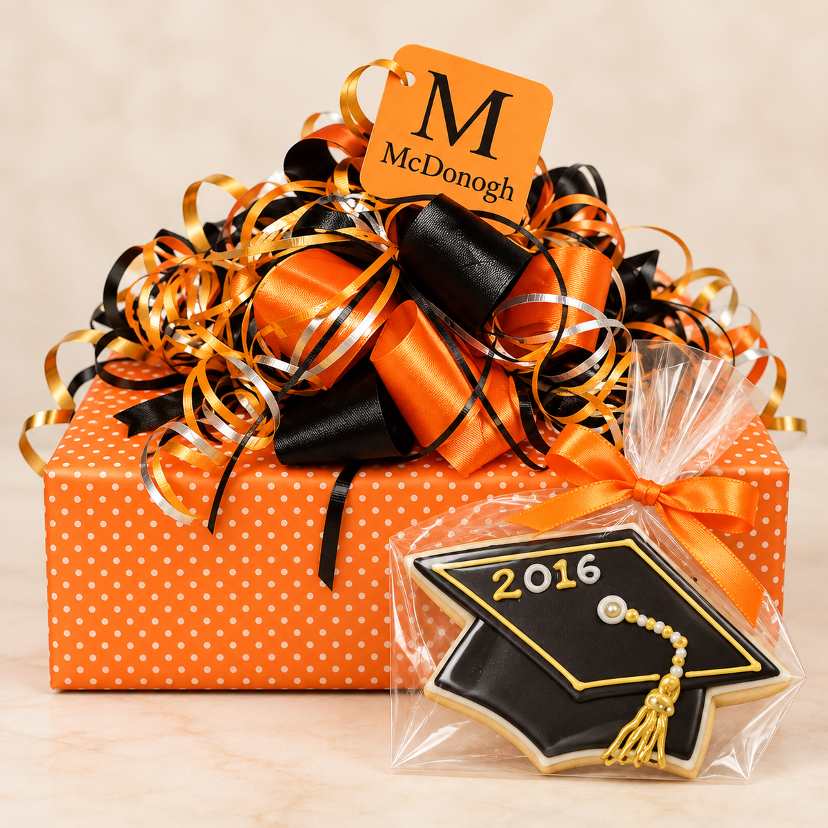 School and collegiate gift box with orange-and-black ribbon, graduation-cap cookie, and custom school accents