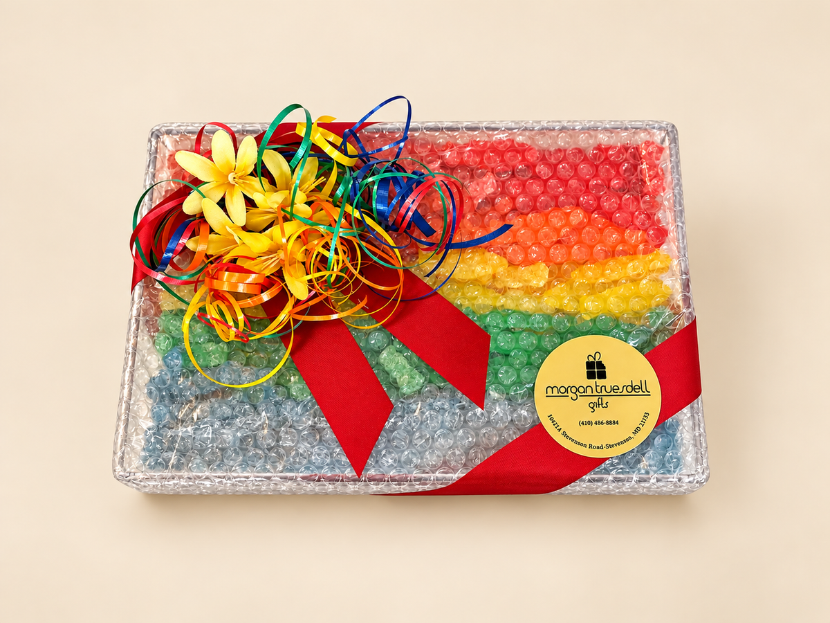 Clear acrylic tray filled with colorful sugar candies, wrapped with red ribbon and a festive bow