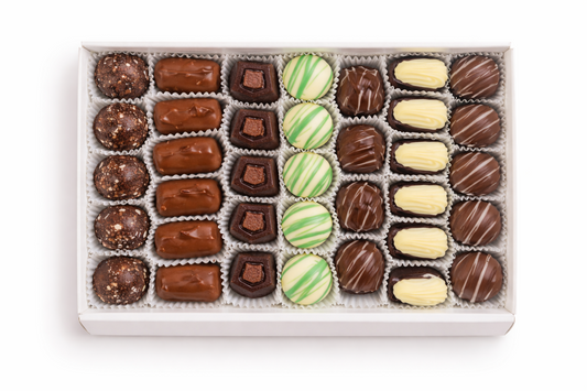 Open box of assorted truffles in paper cups, viewed from above