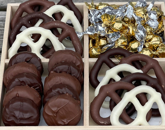 Wooden four-compartment gift box with chocolate pretzels, foil-wrapped candies, and cookies