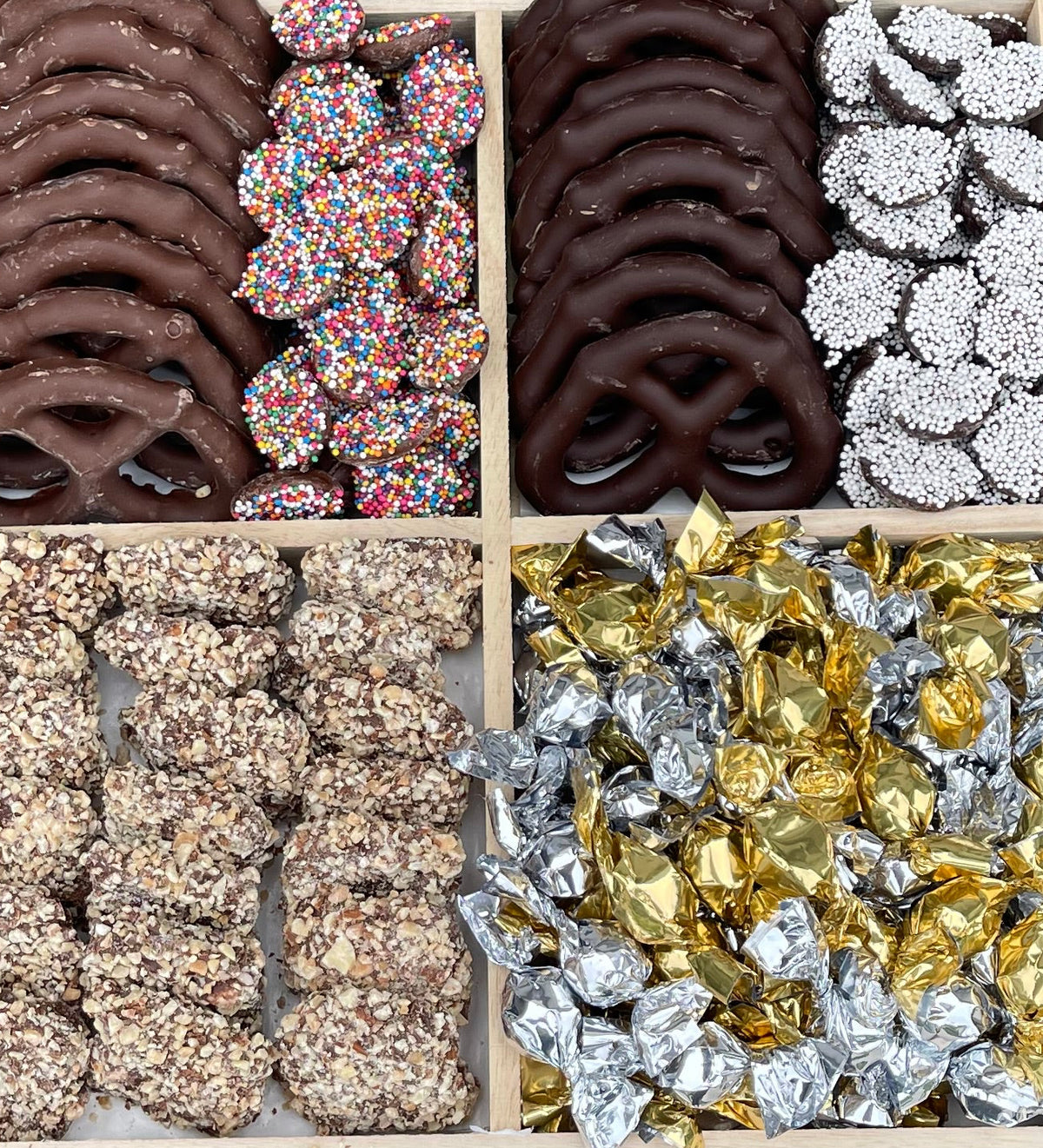 Gift tray with chocolate pretzels, sprinkle treats, and foil-wrapped candies, viewed from above